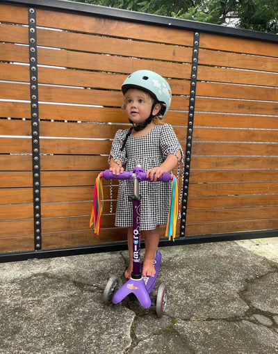 toddler on their purple mini deluxe with neon ribbons