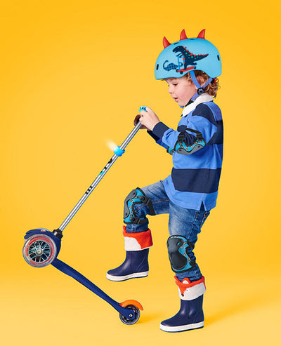boy riding a micro scooter while wearing a 3d dinosaur helmet