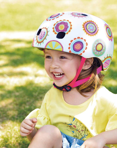 girl wearing a micro scooter doodle dot pattern helmet having fun