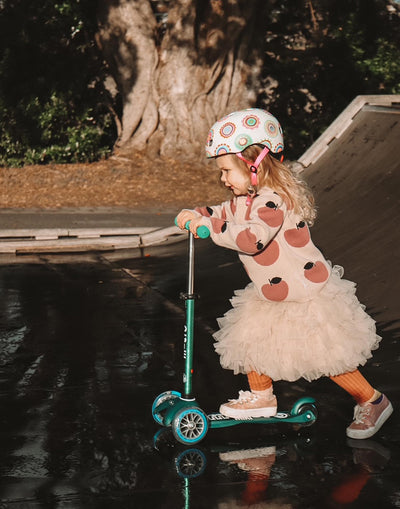toddler riding her deep green mini micro deluxe eco scooter