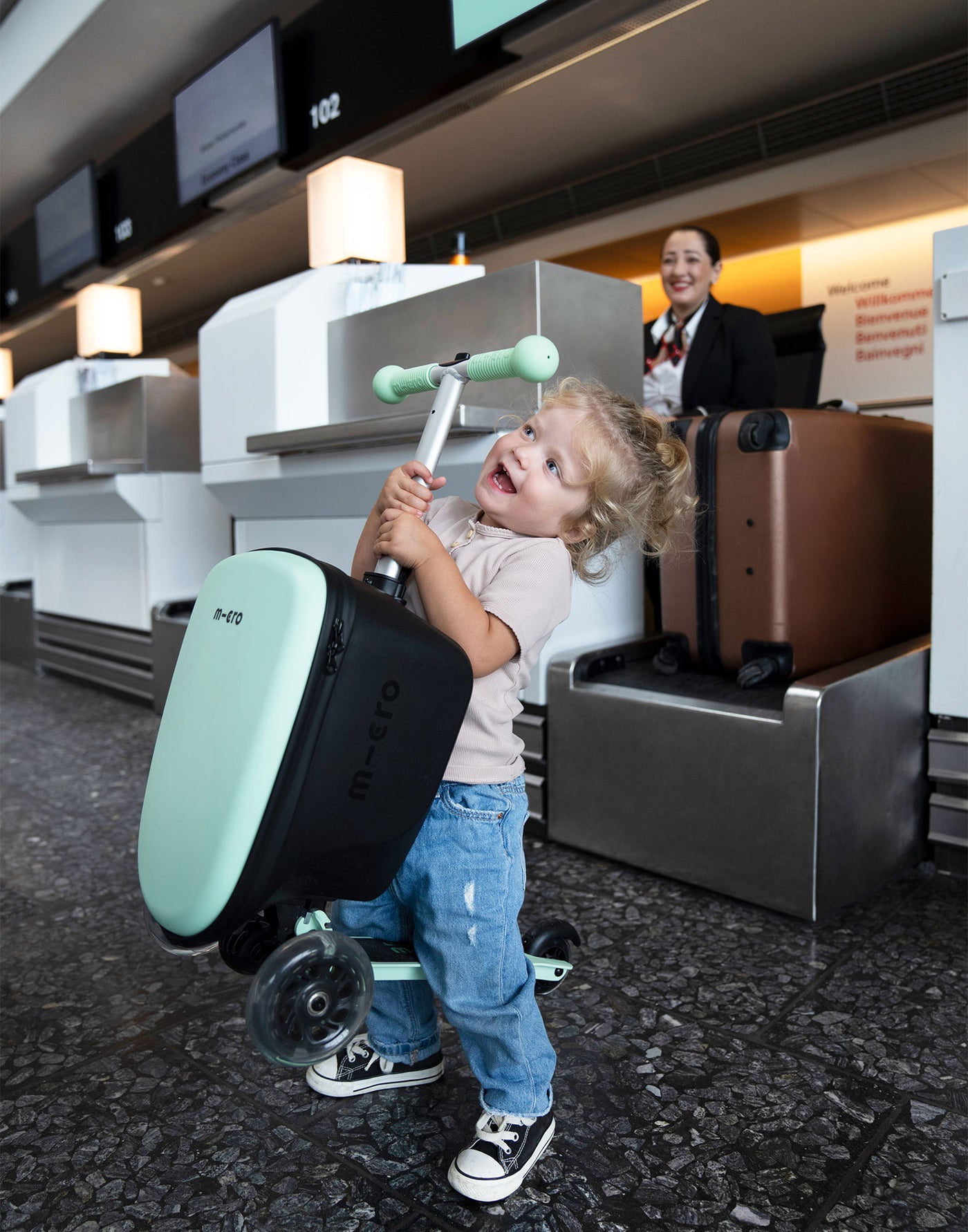 toddler holding her junior luggage scooter at the airport