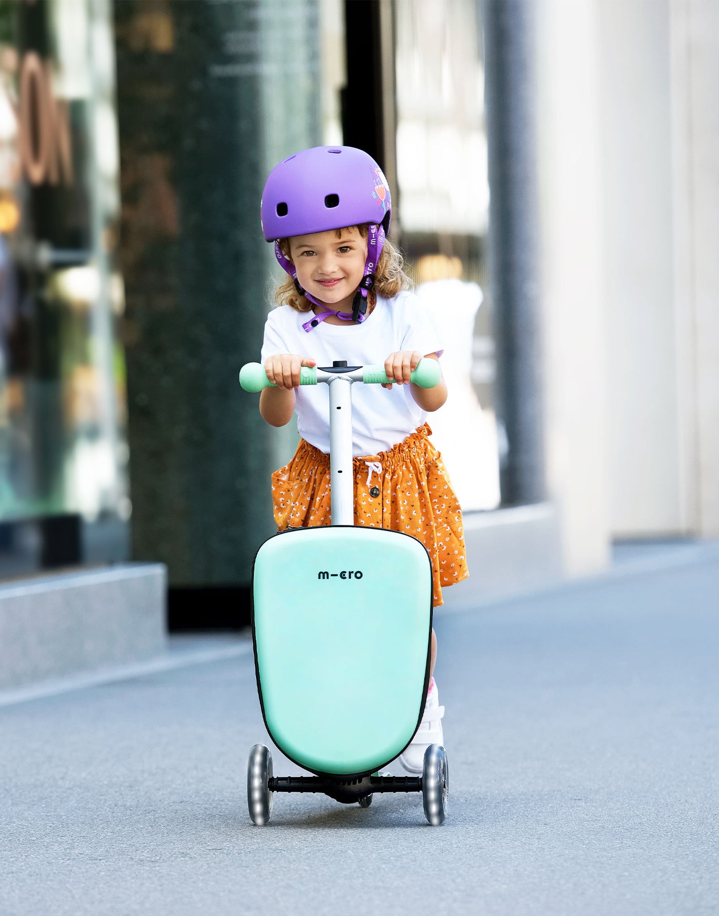 toddler riding her junior luggage scooter