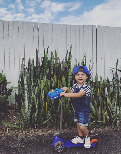 toddler on their blue mini classic scooter with dino head accessory