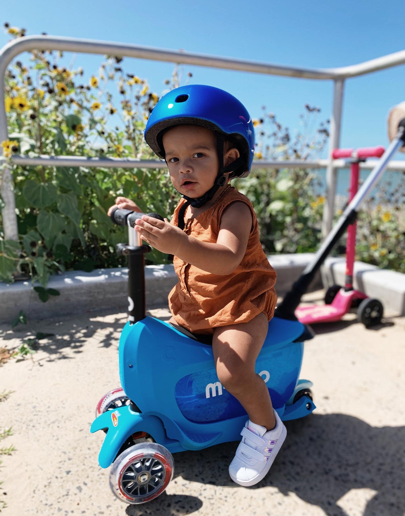 young boy riding his blue mini2go deluxe ride on scooter