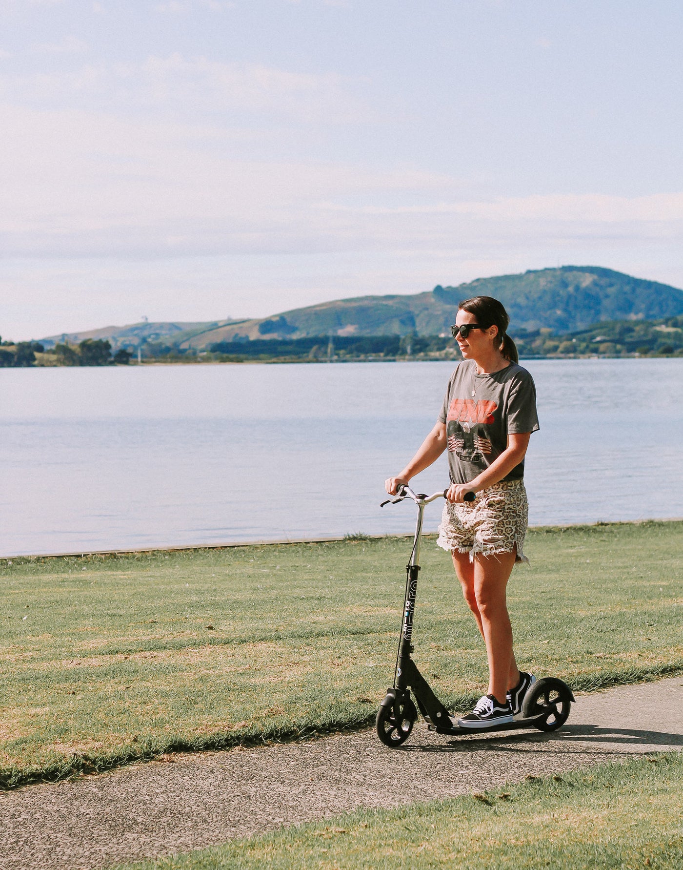 mum riding her downtown adult scooter along the beach