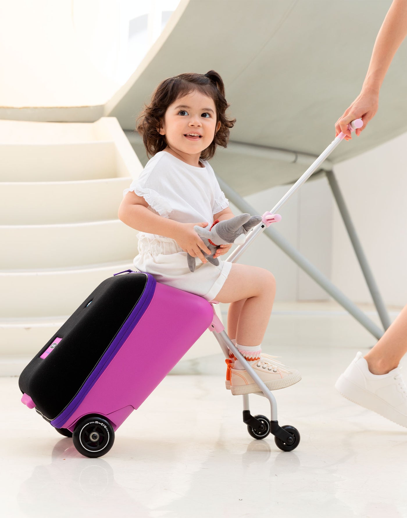 toddler on their favourite ride on luggage suitcase