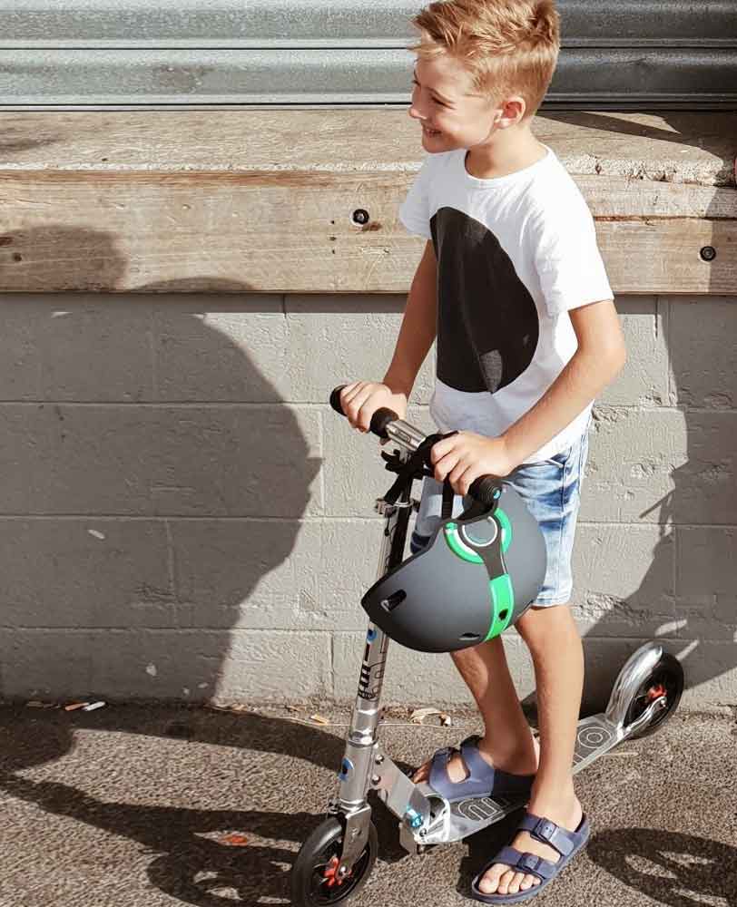 teen riding on a pure silver speed scooter