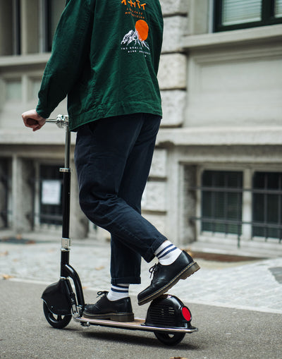 adult riding retro scooter with leather hand grips