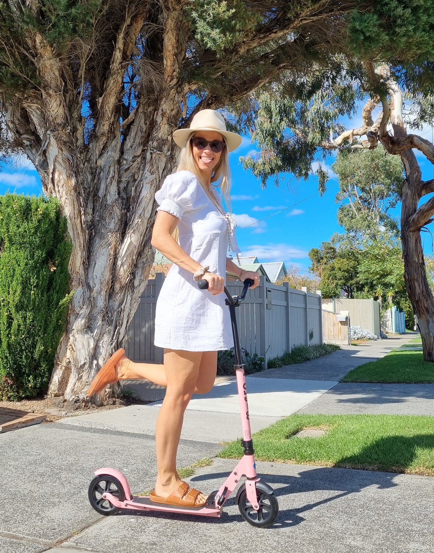 woman on her neon rose pink speed plus deluxe adult scooter