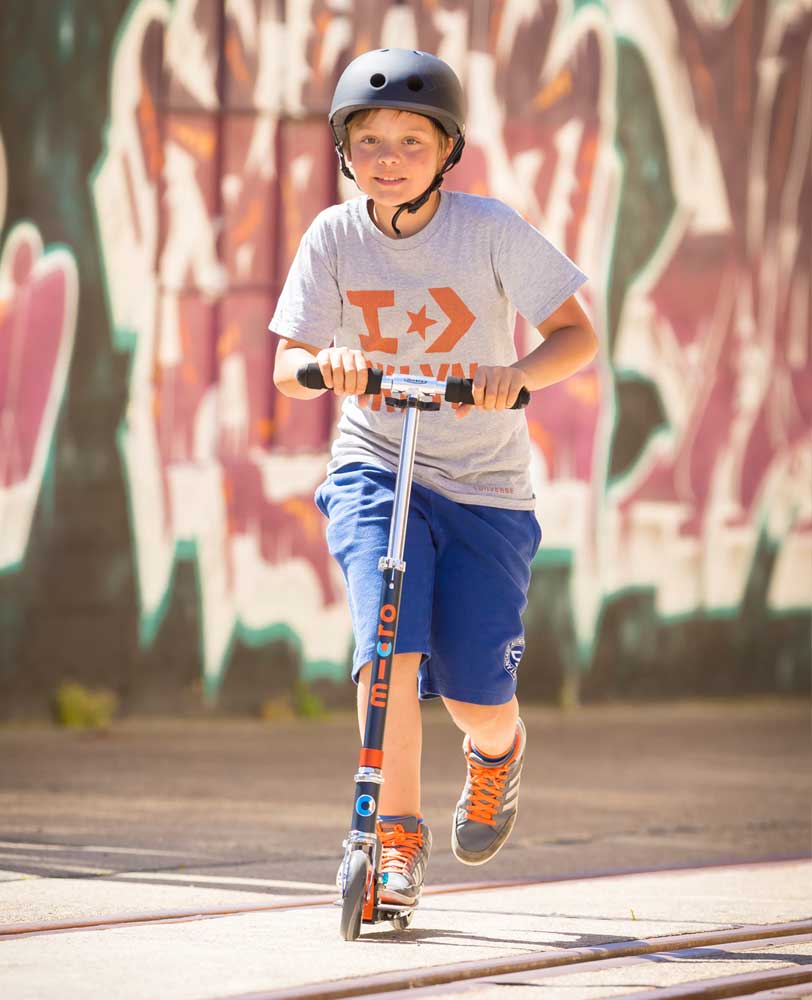 teen riding their favourite orange and black speed scooter