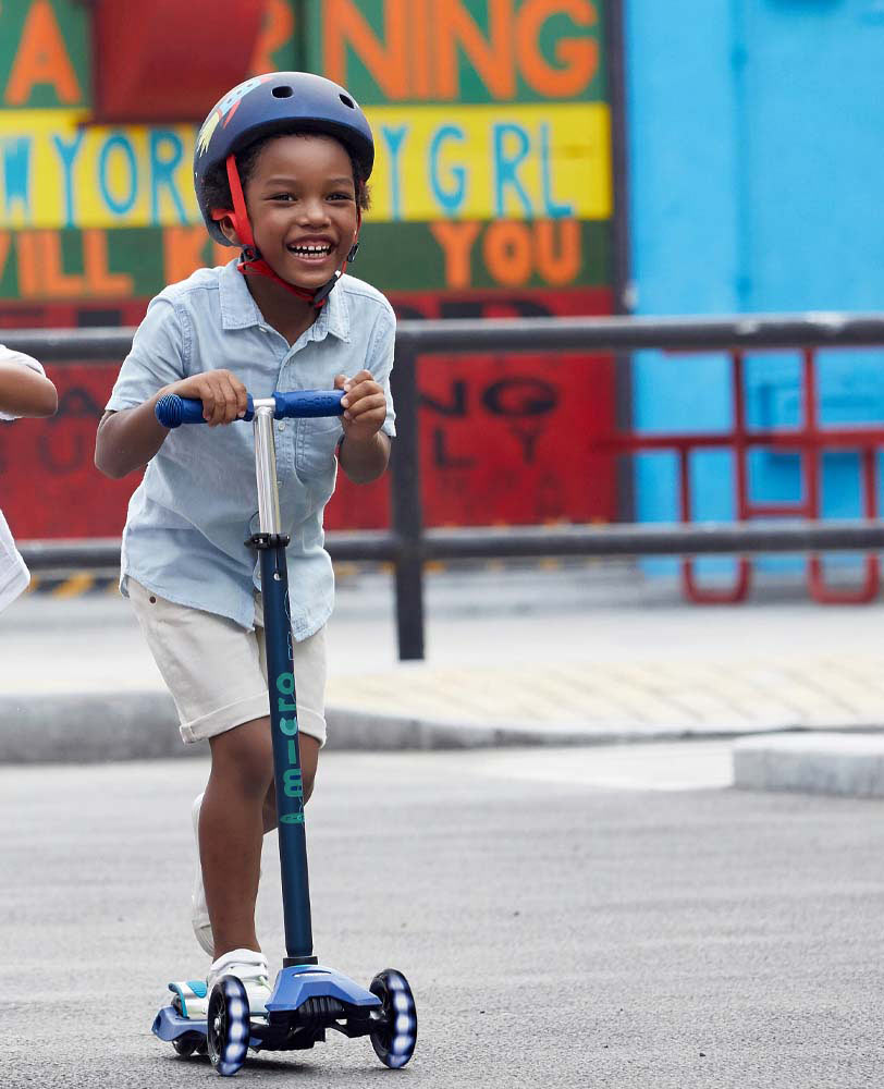 boy riding his navy blue maxi deluxe led scooter