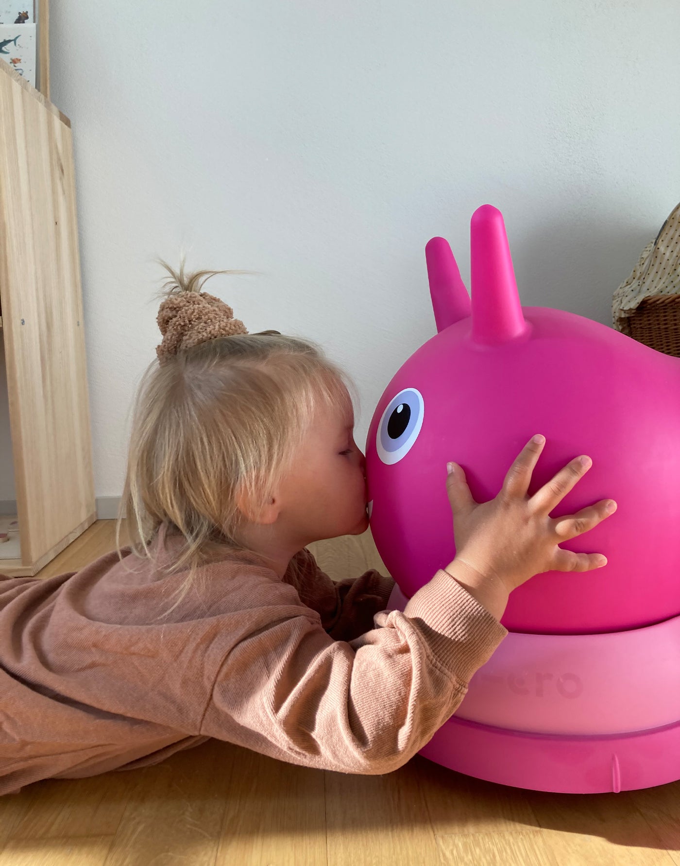toddler kissing her favourite air hopper ride on pink friend