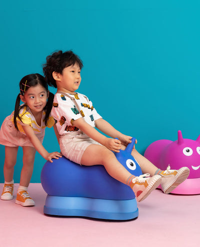 toddlers playing on their pink and blue inflatable ride on air hopper