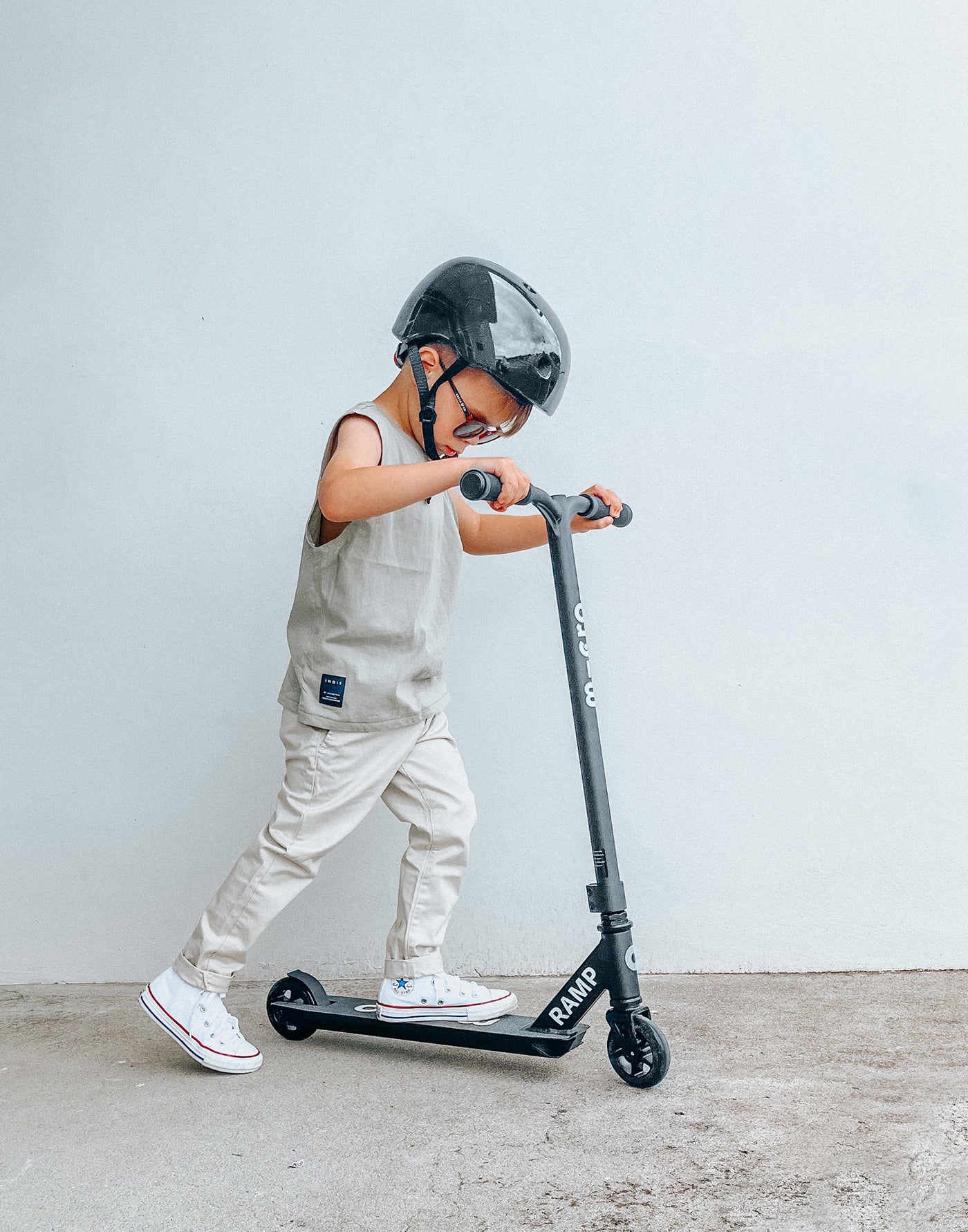 young boy riding a beginner black freestyle scooter